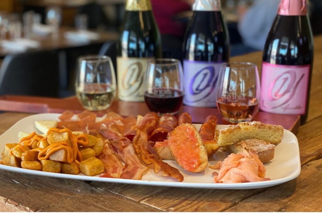 Brunch pairing at Old York Cellars featuring assorted breakfast dishes and wine flights on a wooden table.