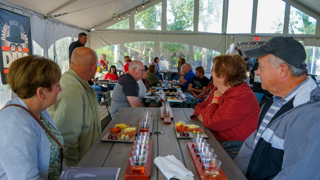 Wine pairing dinner at Old York Cellars in Ringoes, Central NJ, with guests seated at long tables under the vineyard tent, sampling multiple wines and chef‑prepared dishes.