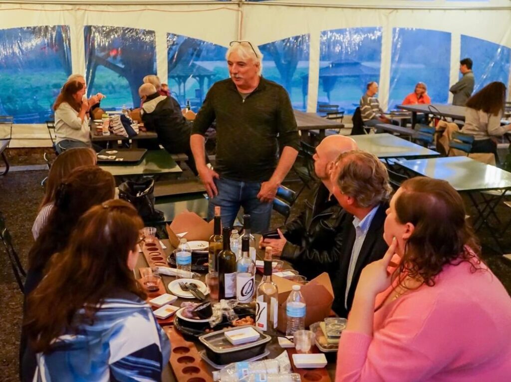 Group gathered under the Vineyard tent enjoying wine and food while Winemaker, Darren Hesinton chats with guests at Old York Cellars.