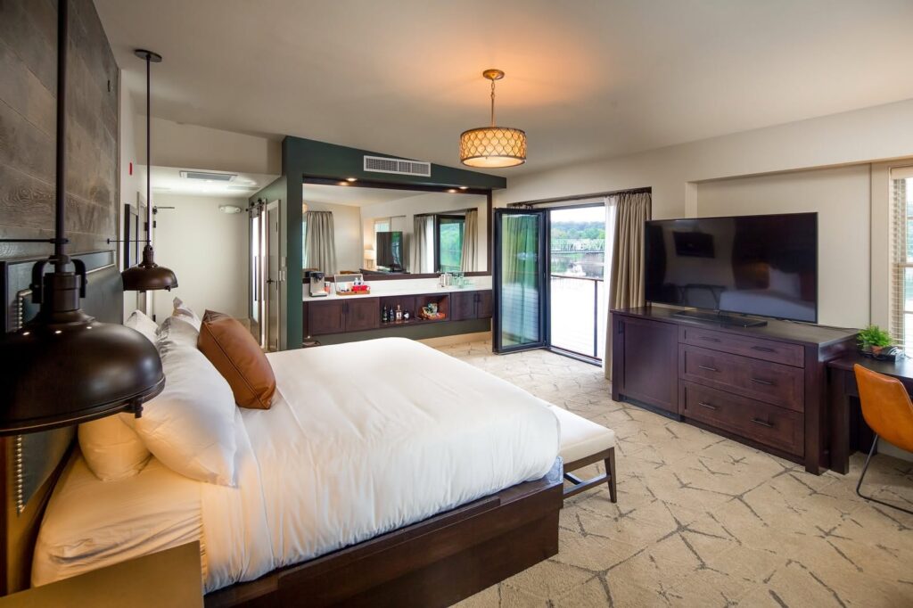 Spacious guest room at Ghost Light Inn with a king bed, modern furnishings, and large windows overlooking the Delaware River.
