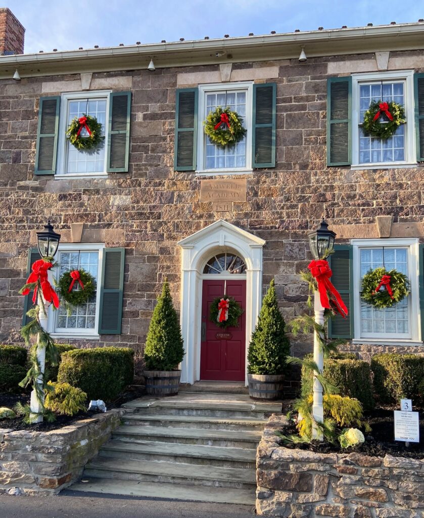 Historic stone building decorated with wreaths and red bows for the holidays.