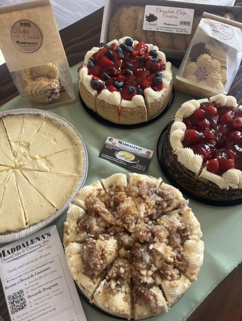 Assorted cheesecakes and baked goods from Maddalena’s Cheesecake arranged on a counter.