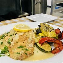A lemon‑topped fish fillet served with grilled zucchini and red peppers in a light sauce, a classic pairing for Old York Cellars white wines at Mama Fanti of Hillsborough NJ.