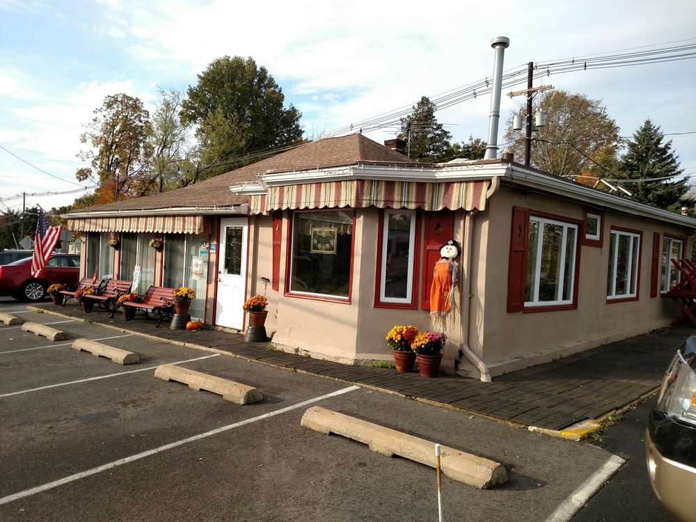 Mom’s Restaurant building with striped awnings and fall decorations in the parking lot.