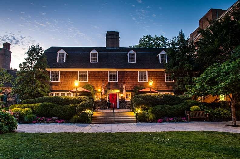 Front view of Nassau Inn illuminated at dusk with warm exterior lighting and landscaped greenery along the walkway.