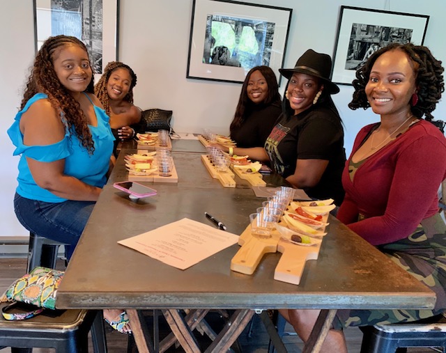 Group of six friends smiling and tasting wine indoors at Old York Cellars.