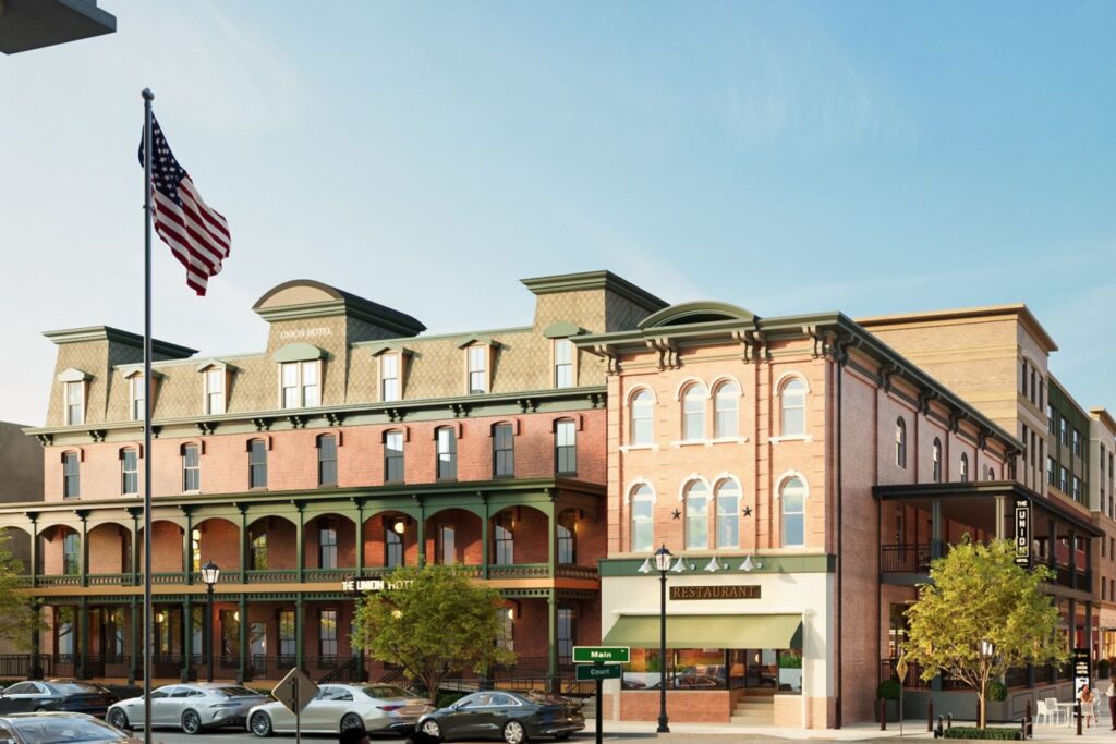 Exterior view of The Union Hotel in downtown Flemington, New Jersey — a Marriott Tribute Portfolio Hotel with historic brick architecture and an American flag flying at the corner.
